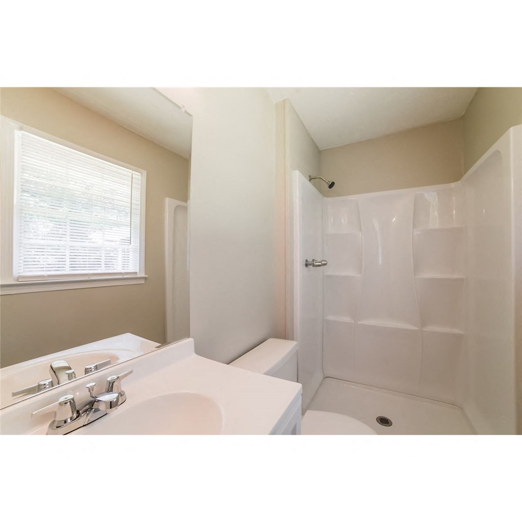 a bathroom with a sink and a shower and a toilet