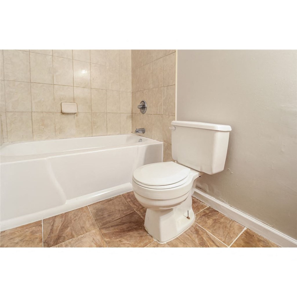 a bathroom with a toilet and a bath tub