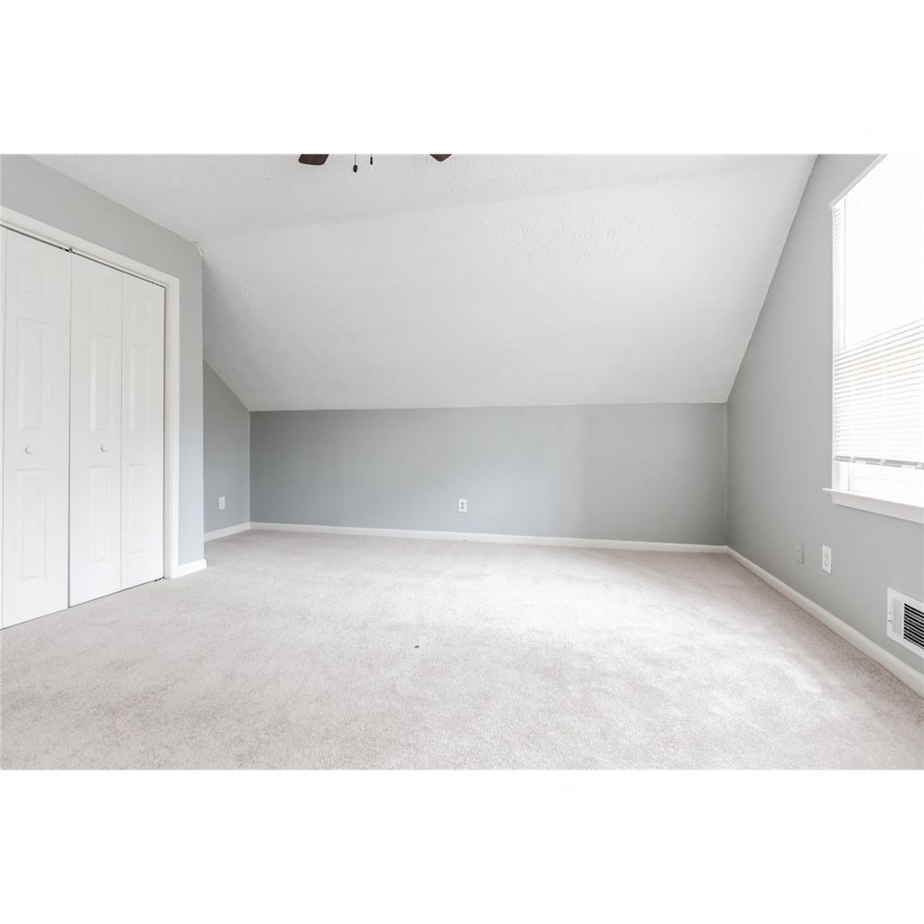 an empty bedroom with a closet and a window