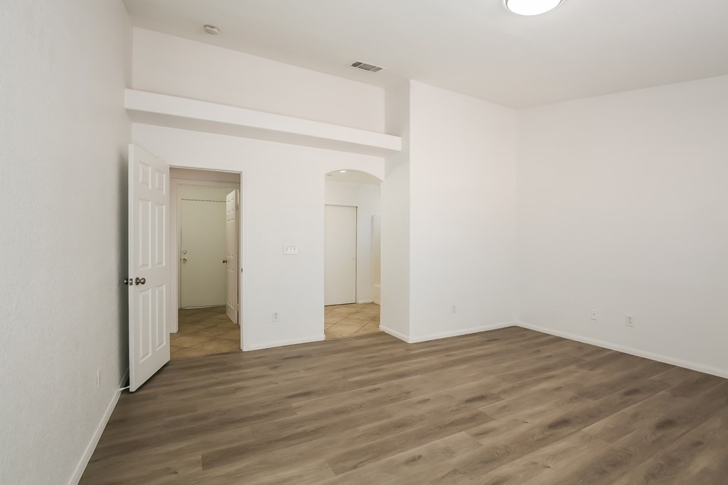 A room with wooden flooring and white walls.