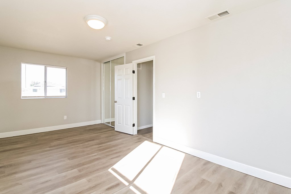 A room with a white door and a white rug on the floor.