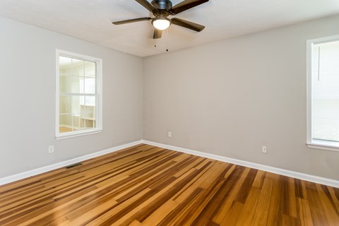 A room with wooden floors and a ceiling fan.