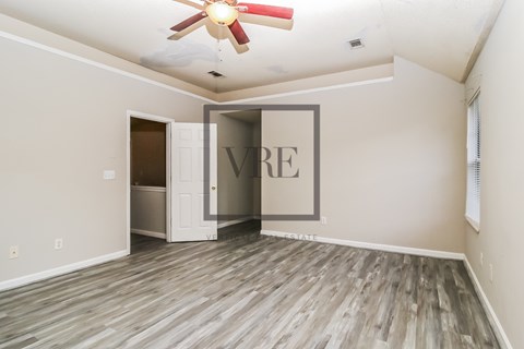 A room with a ceiling fan and a door with a sign that says "VIBE".