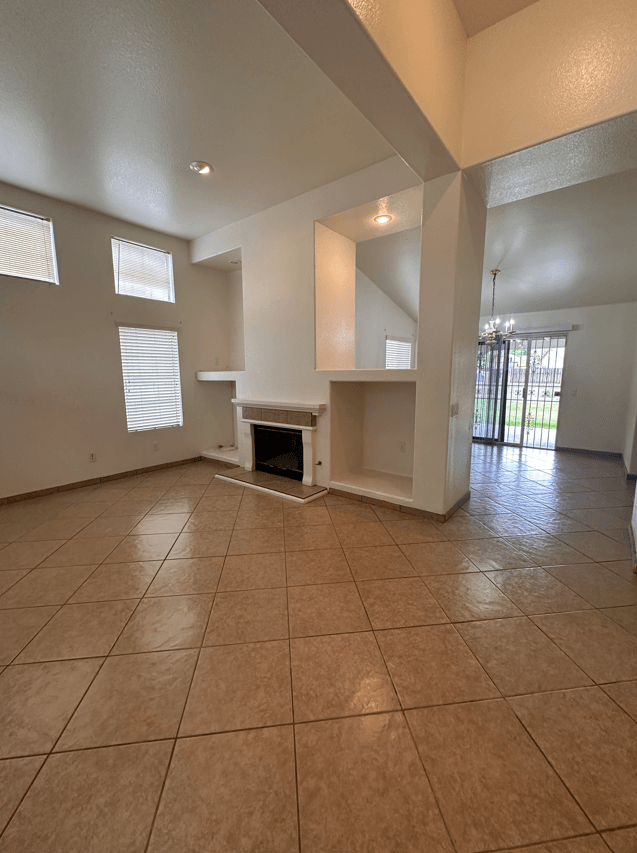 the living room of an empty house with a fireplace