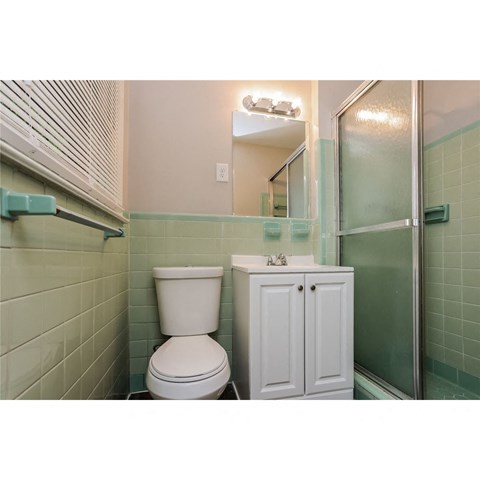 a bathroom with a toilet and a sink and a shower