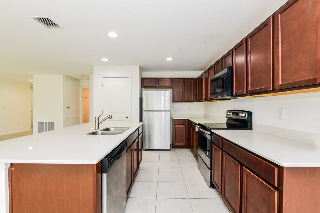 A kitchen with brown cabinets and white countertops.