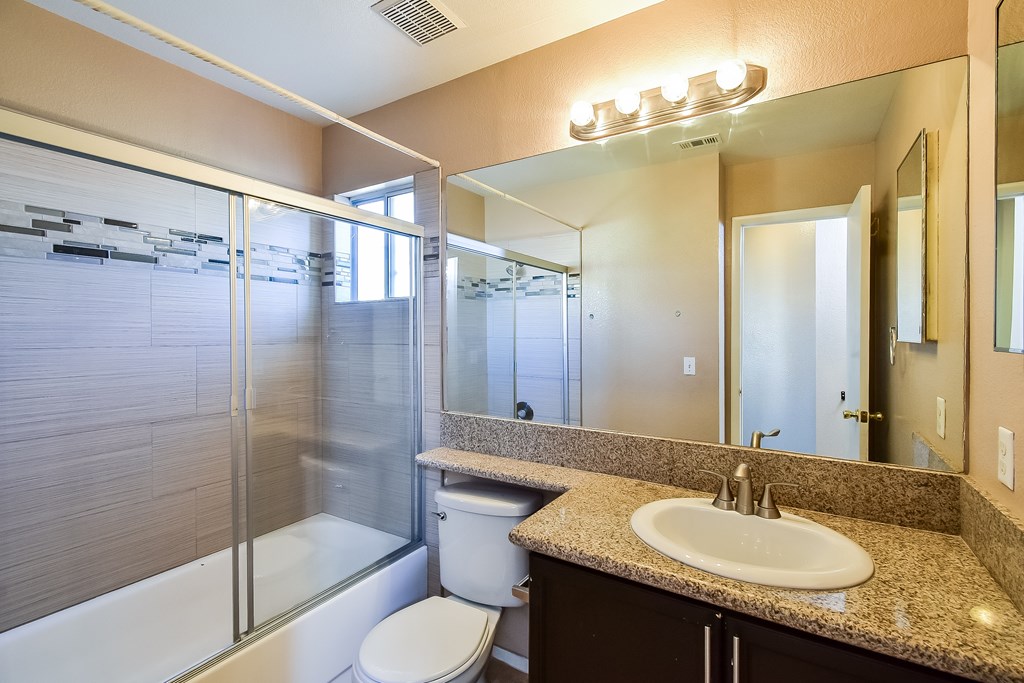 A bathroom with a sink, toilet, and shower.