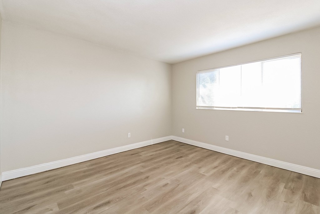 A room with wooden flooring and a window.