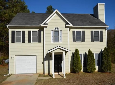 A house with a white garage door and a black roof.