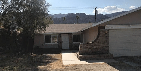 A house with a brown roof and a white door is shown.