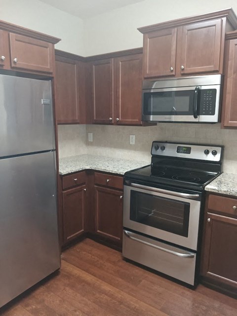 a kitchen with stainless steel appliances and wooden cabinets