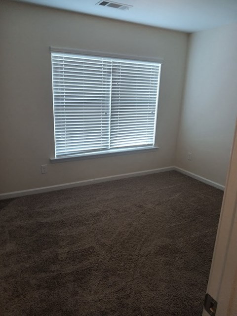 a room with a window and a carpet