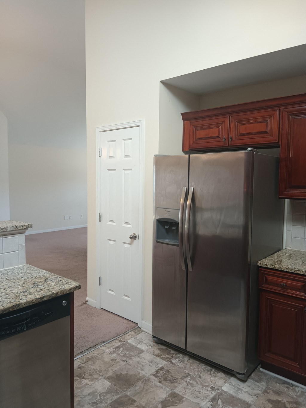 a kitchen with a stainless steel refrigerator and wooden cabinets