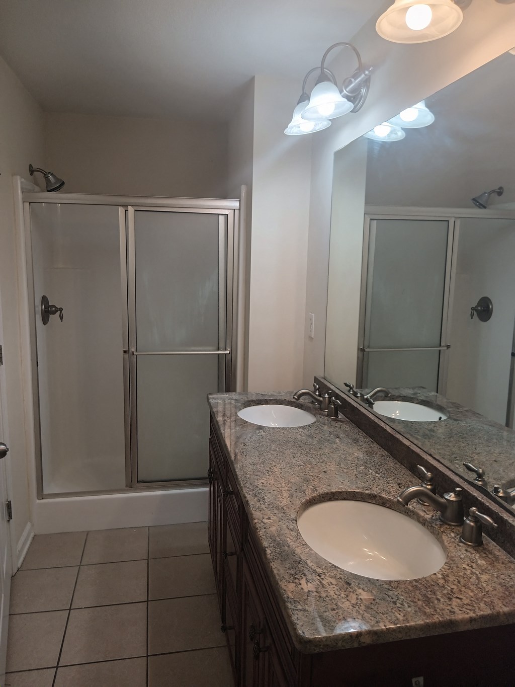 a bathroom with two sinks and a shower
