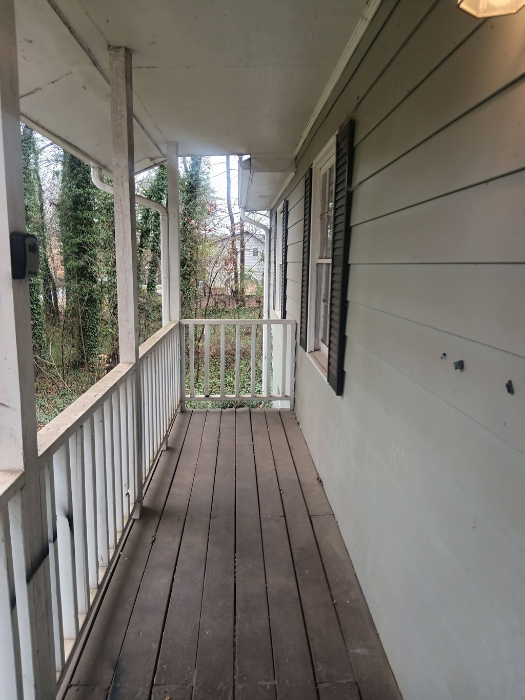 A wooden deck with a white railing and a light on.