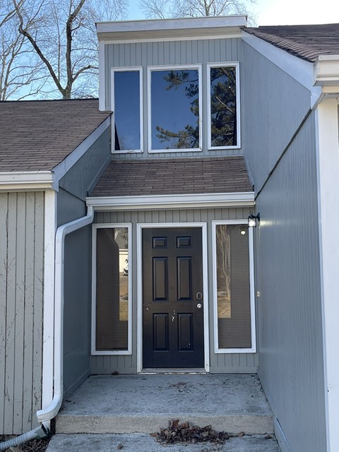 A house with a grey exterior and a dark brown door.