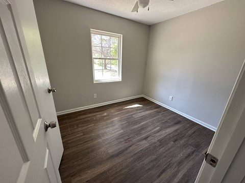 A room with a wooden floor and a window.