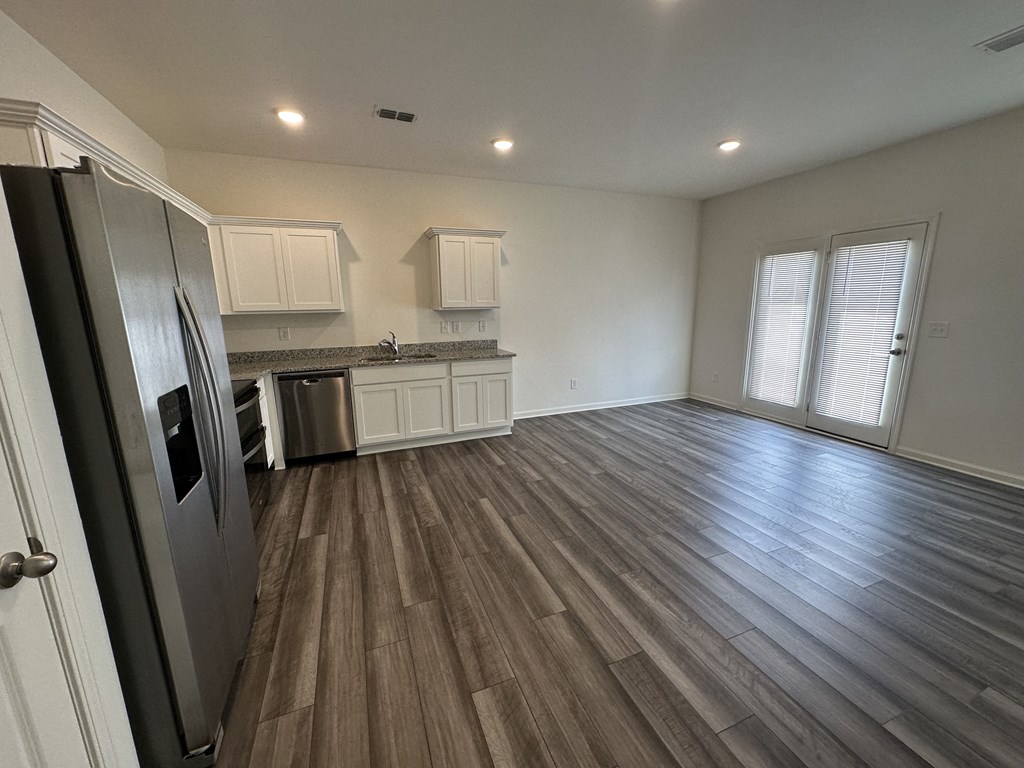 an empty kitchen and living room with hardwood flooring