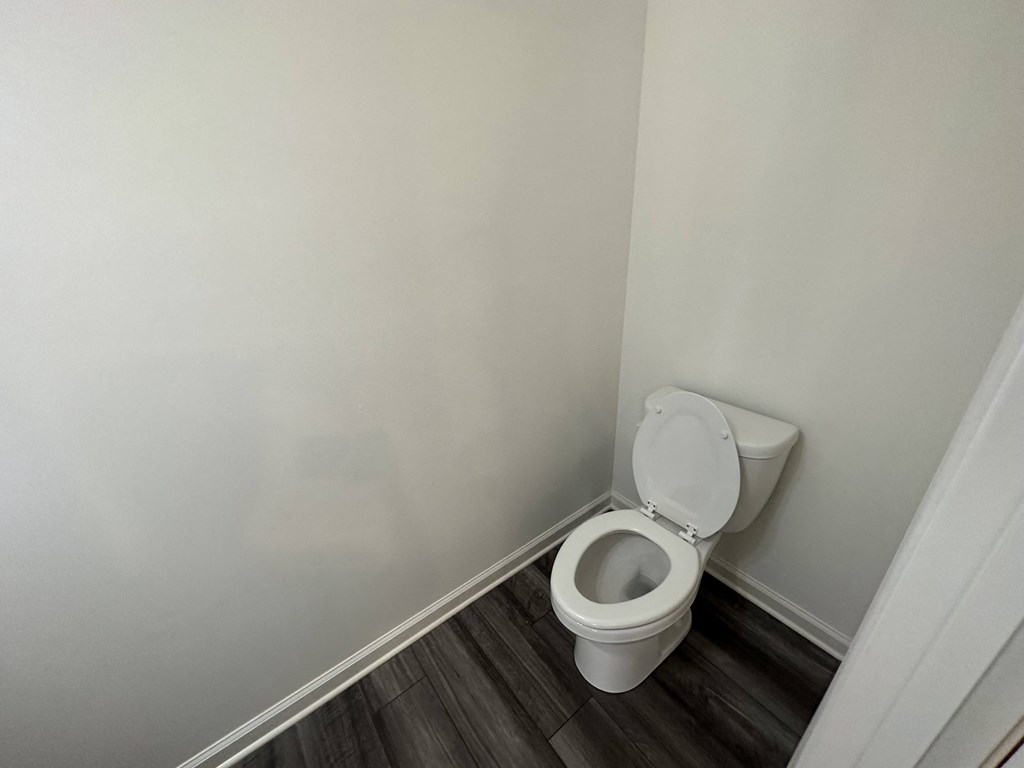 an empty bathroom with a toilet in the corner
