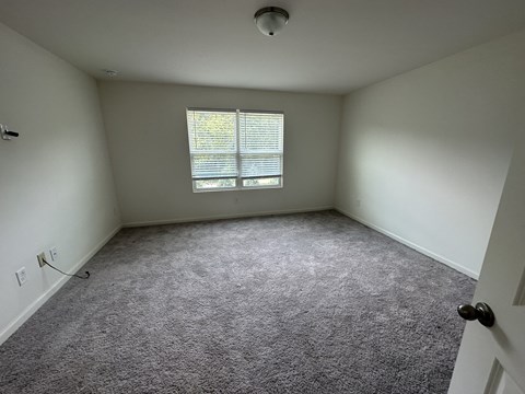 an empty room with carpet and a window