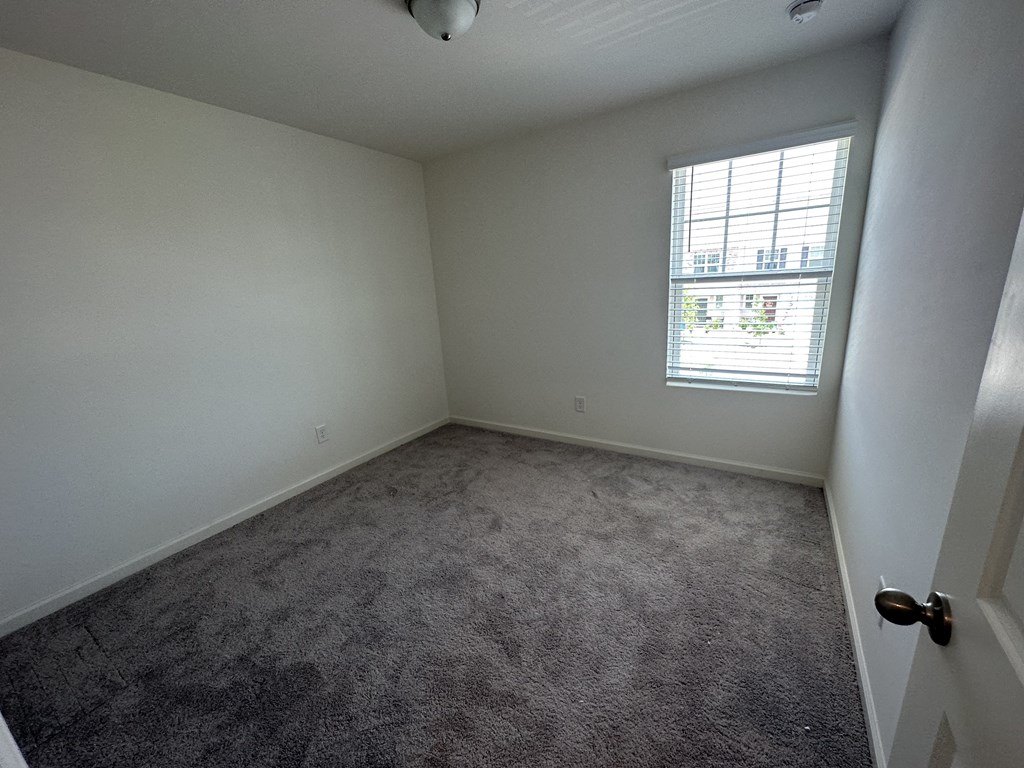 an empty room with carpet and a window