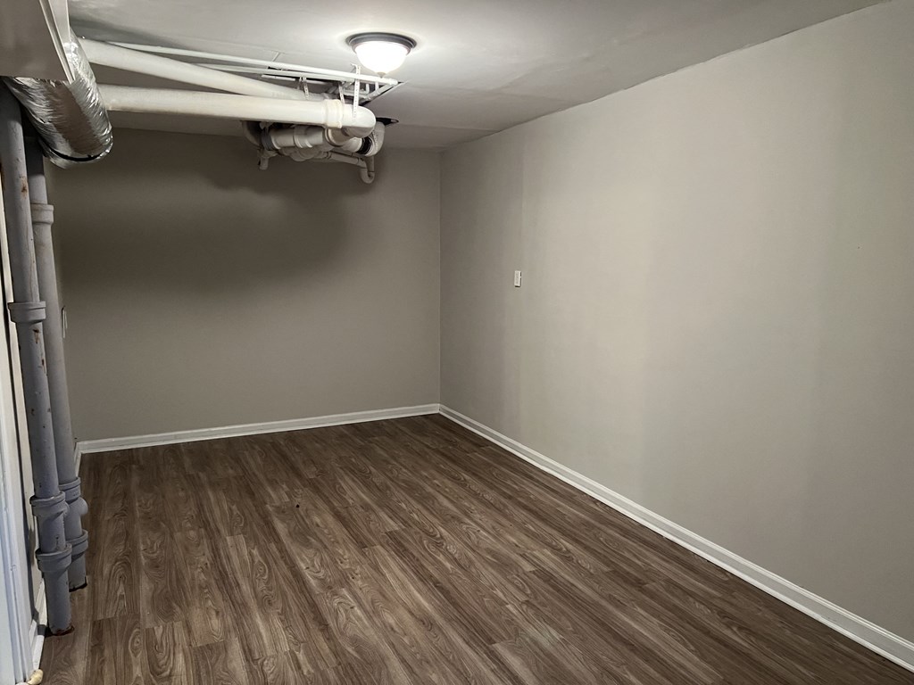 an empty room with wood flooring and a bunk bed