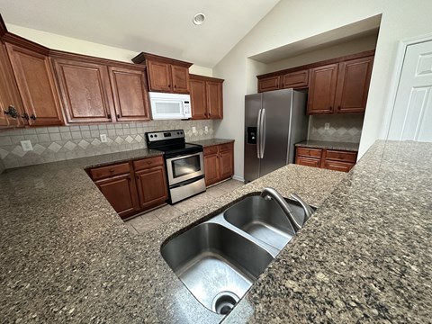 a kitchen with stainless steel appliances and granite counter tops