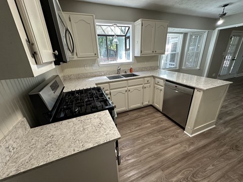A kitchen with a stove top oven and a refrigerator.