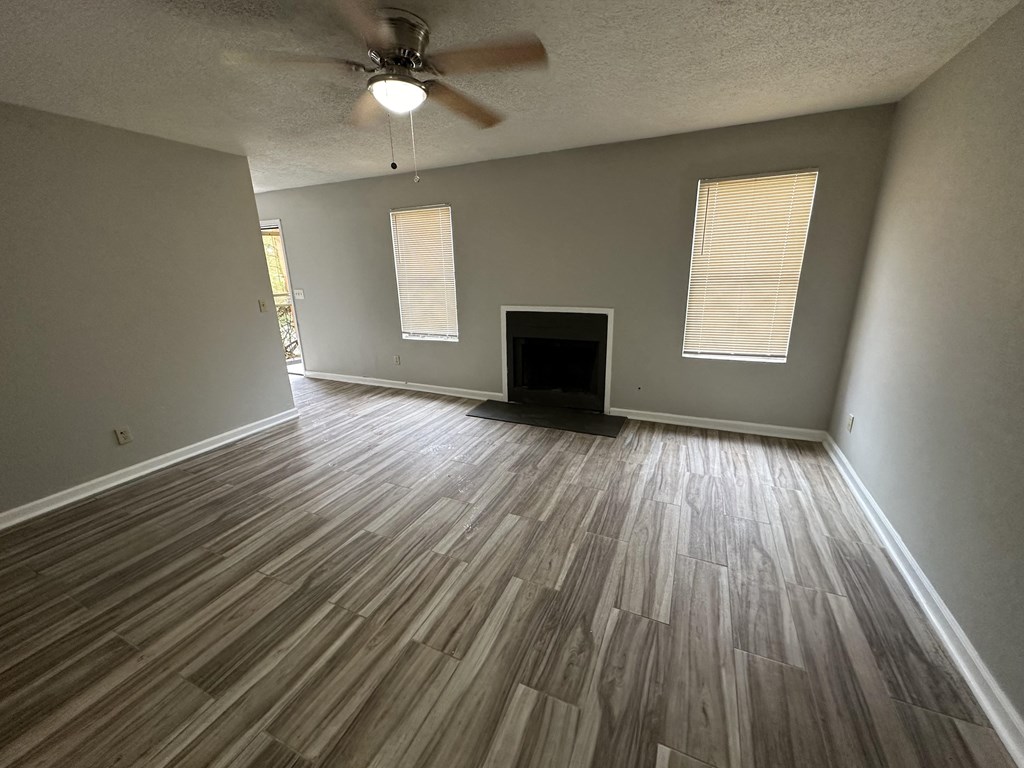 an empty living room with wood floors and a fireplace