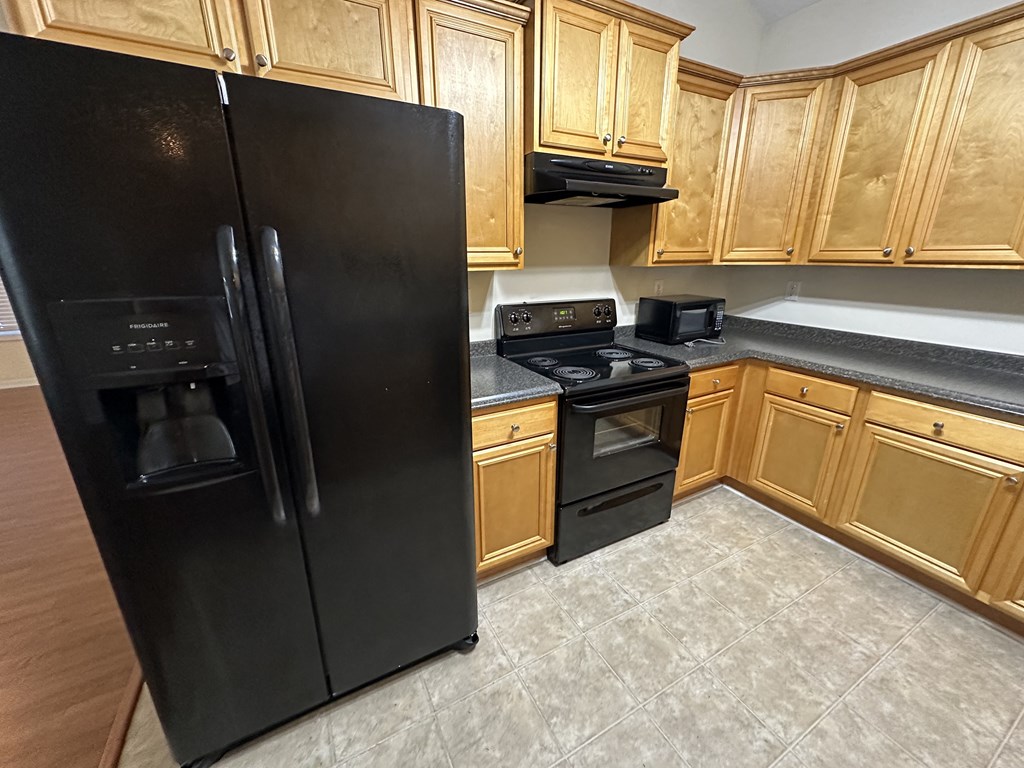 a kitchen with black appliances and wooden cabinets
