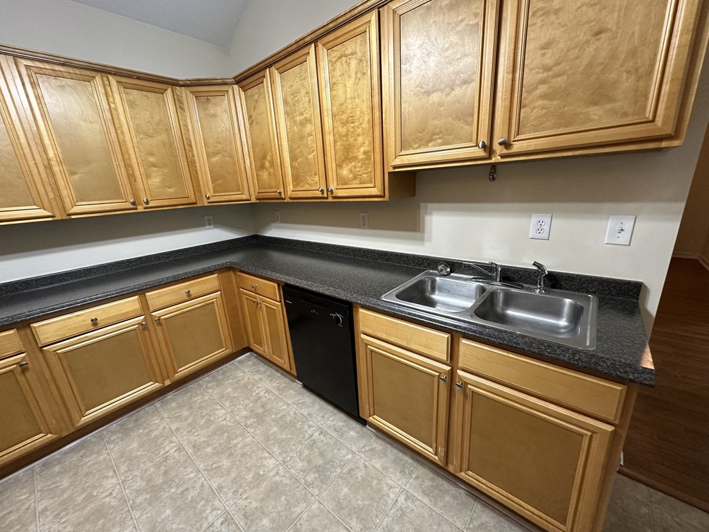 an empty kitchen with wooden cabinets and a sink