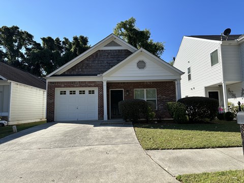 a brick house with a white garage door and a driveway
