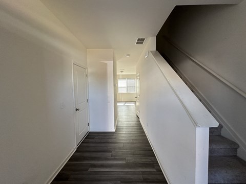 a view of the hallway from the bottom of the stairs looking into the living room