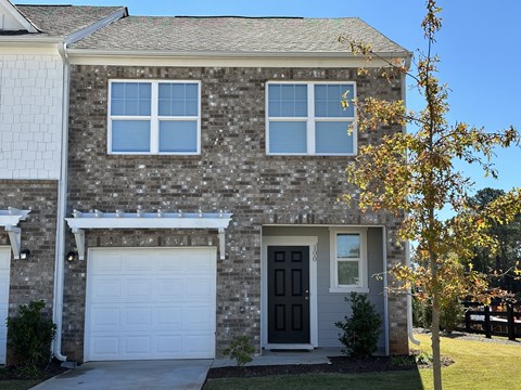 the front of a brick house with a black door