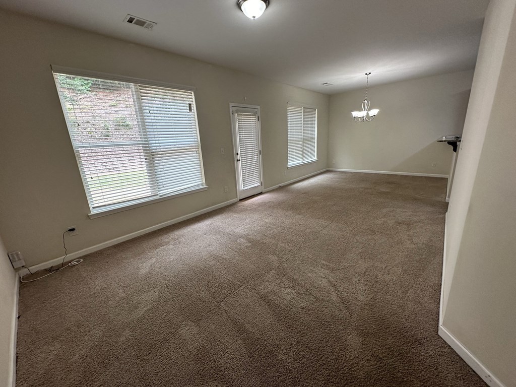 an empty living room with carpet and a large window