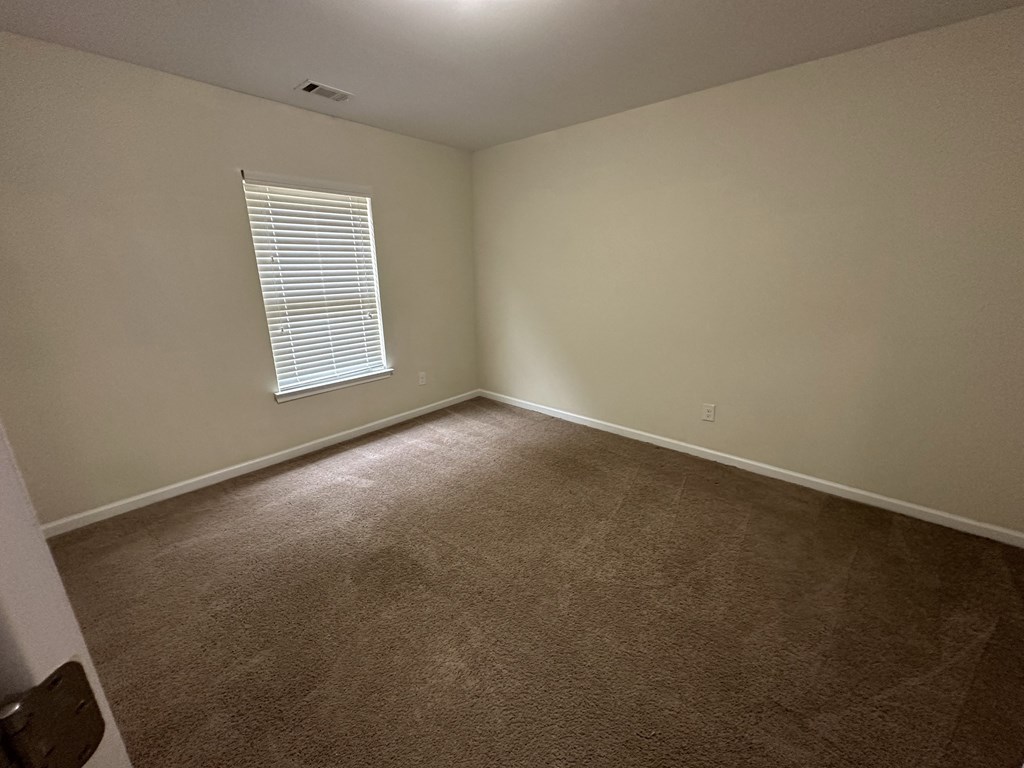 an empty room with carpet and a window