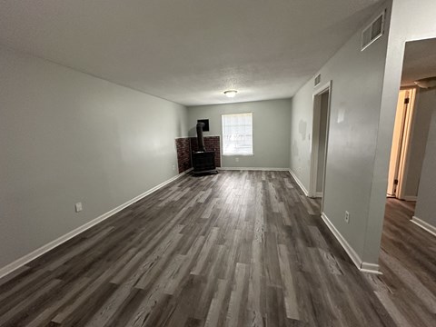 a living room with hardwood floors and grey walls and a window