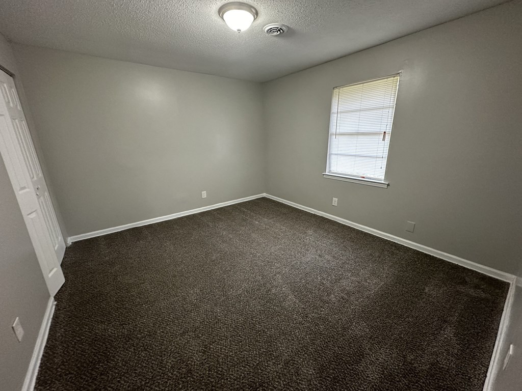 an empty room with carpet and a window