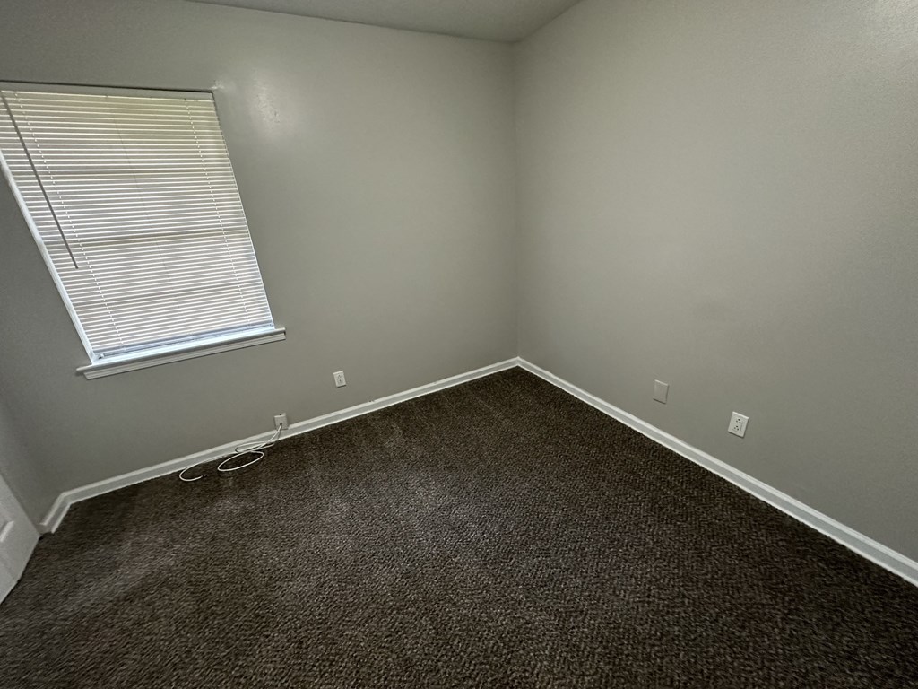 an empty room with carpet and a window