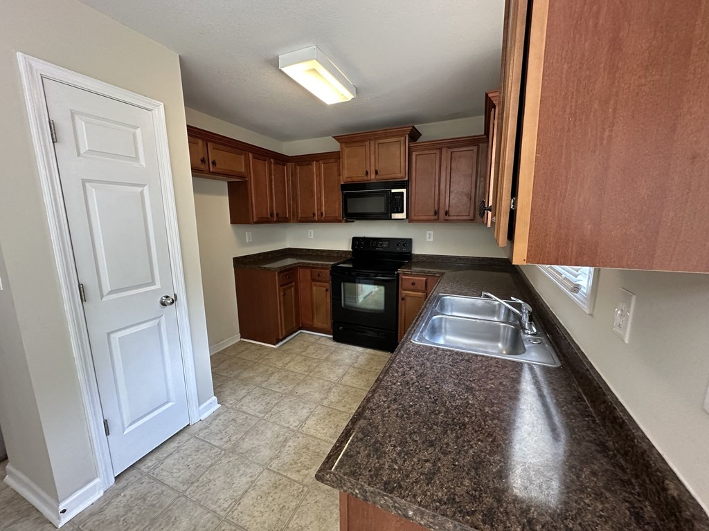 a kitchen with granite counter tops and wooden cabinets