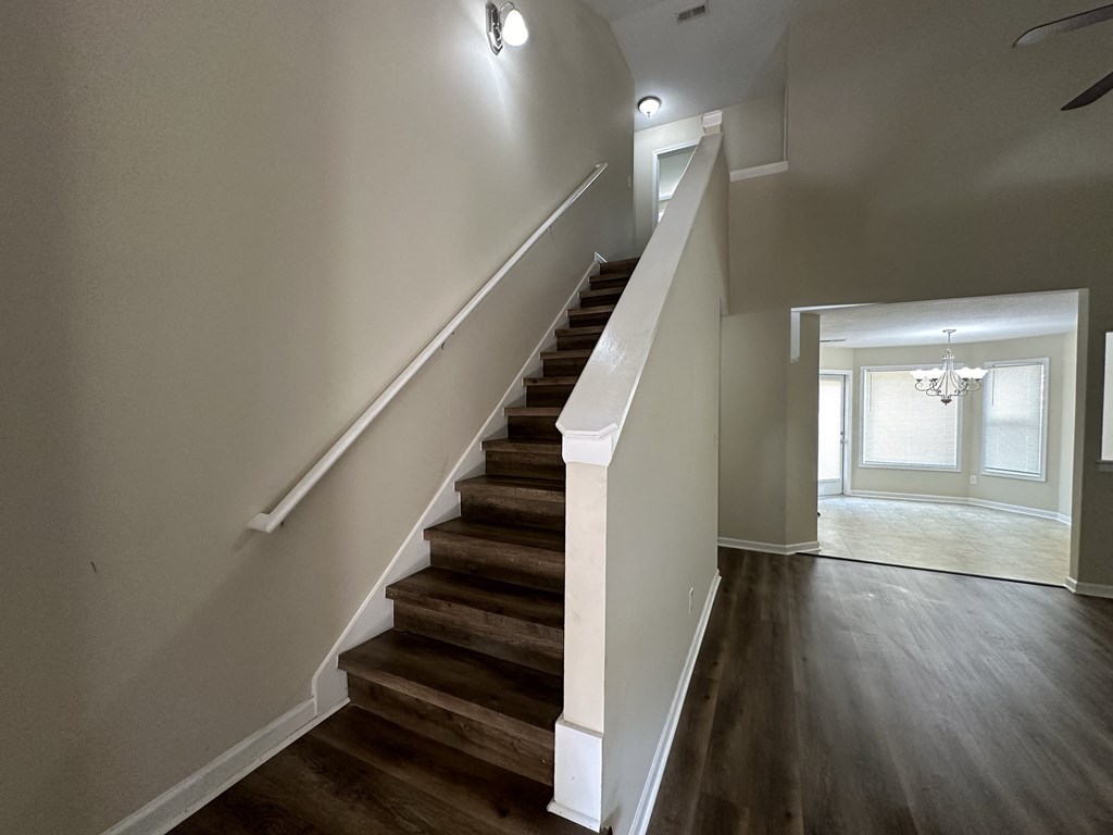 a view of a staircase in a home with wood floors and white walls
