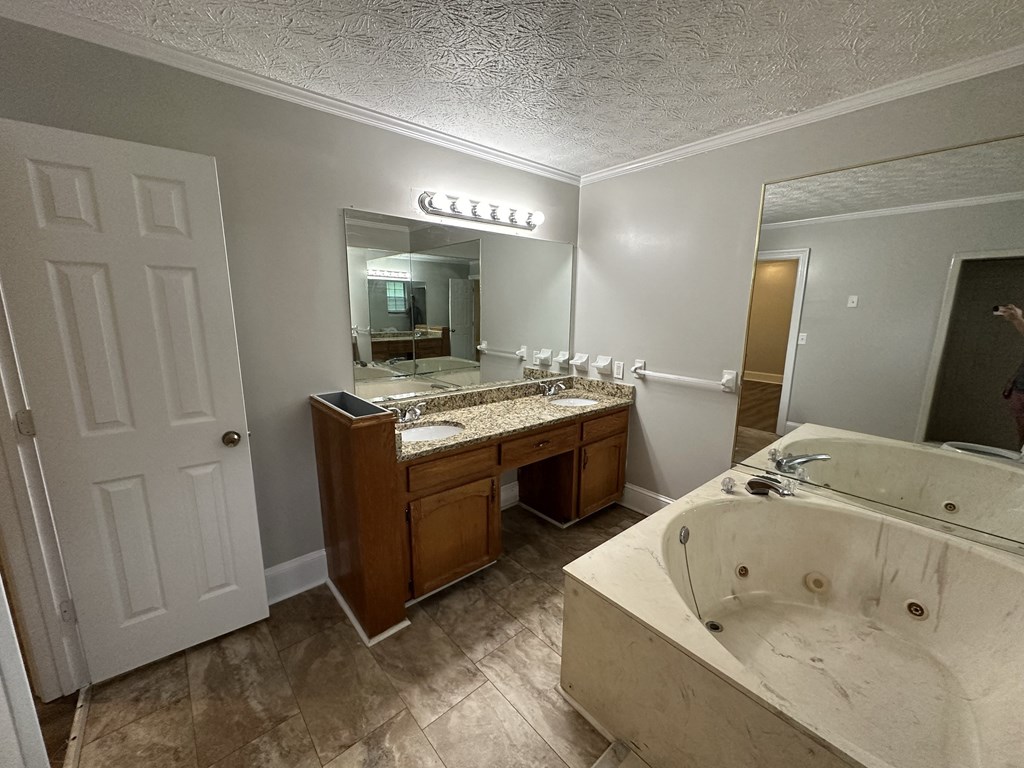 a bathroom with a large tub and a sink and a mirror