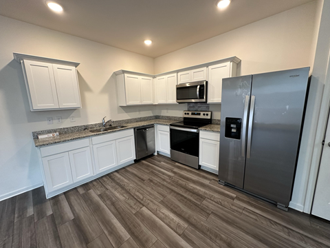 a kitchen with white cabinets and stainless steel appliances
