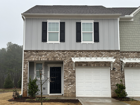 a house with two garage doors and two white doors