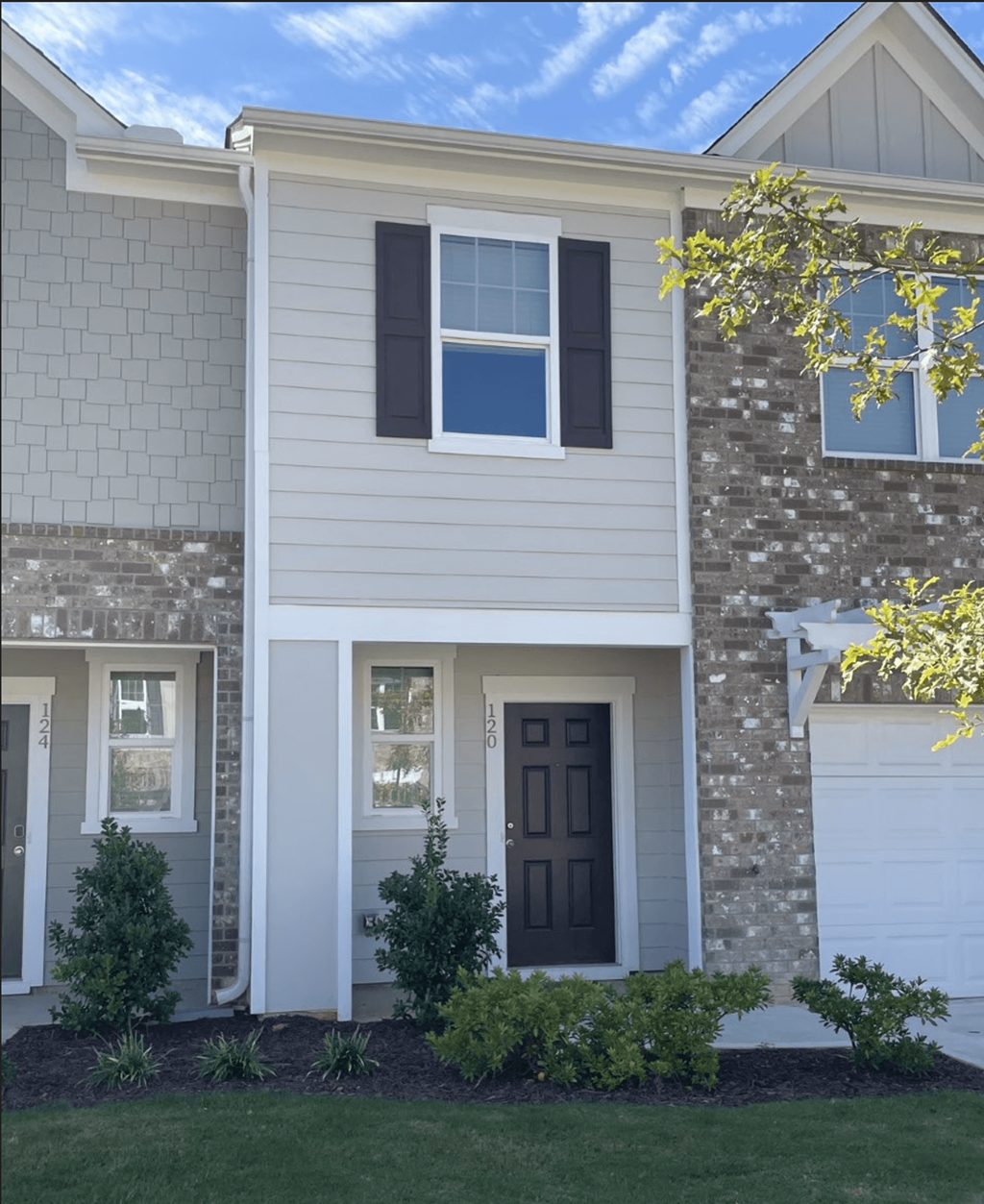 a white house with a black door and a white and gray house