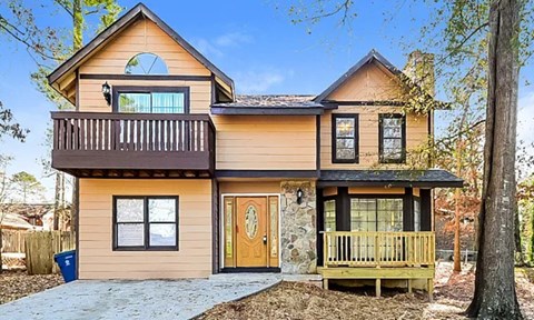 A two-story house with a balcony and a deck.