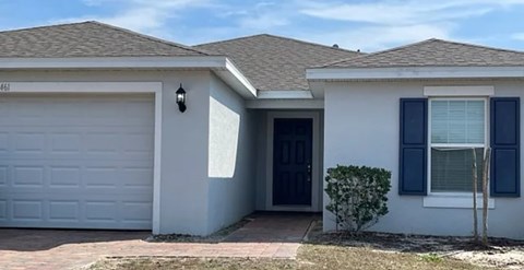 A house with a white garage door and a black door.