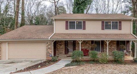 A house with a brown roof and a covered porch.
