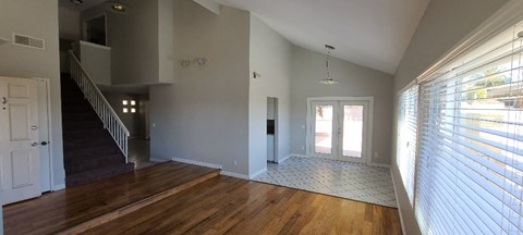 a living room with a wooden floor and a door
