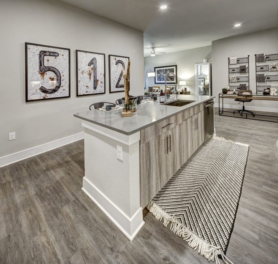 A kitchen with a white island and a rug on the floor at Arise Riverside Apartments, Austin, 78741